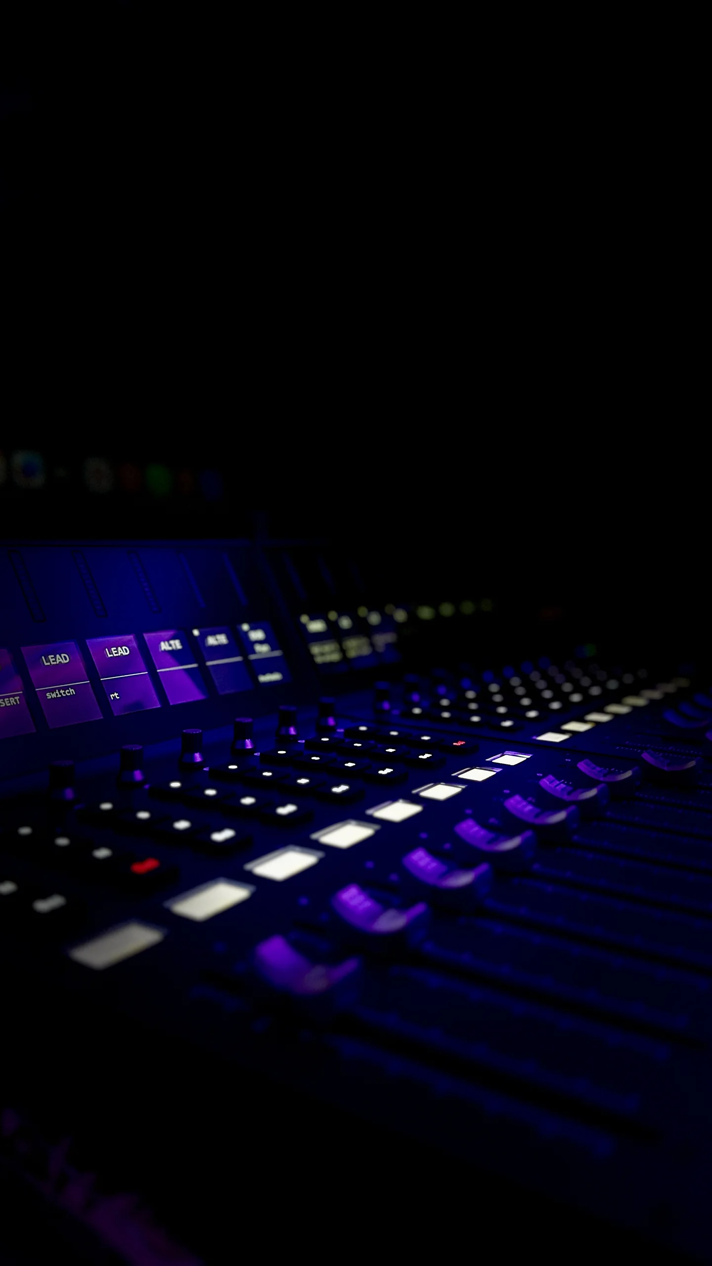 Lunar Mansion Studios mixing console faders and channel strips in moody purple lighting